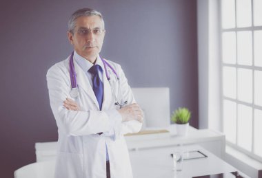 Parlak ofisinde gülümseyen bir doktorun portresi.