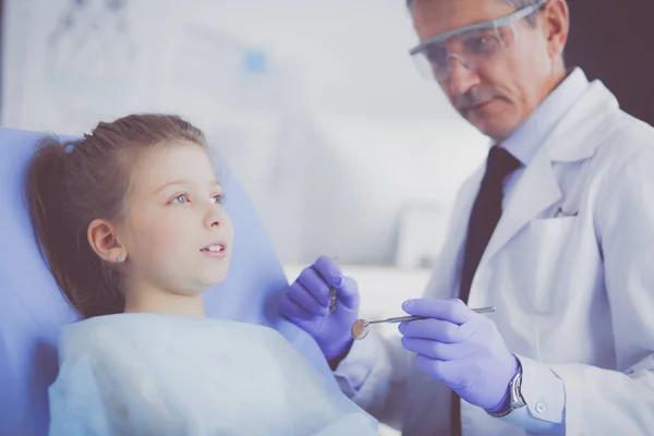 Kleines Mädchen sitzt in der Zahnarztpraxis — Stockfoto