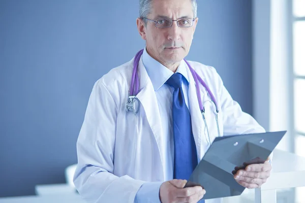 Ärztin schreibt Notizen auf Klemmbrett im Krankenhaus — Stockfoto