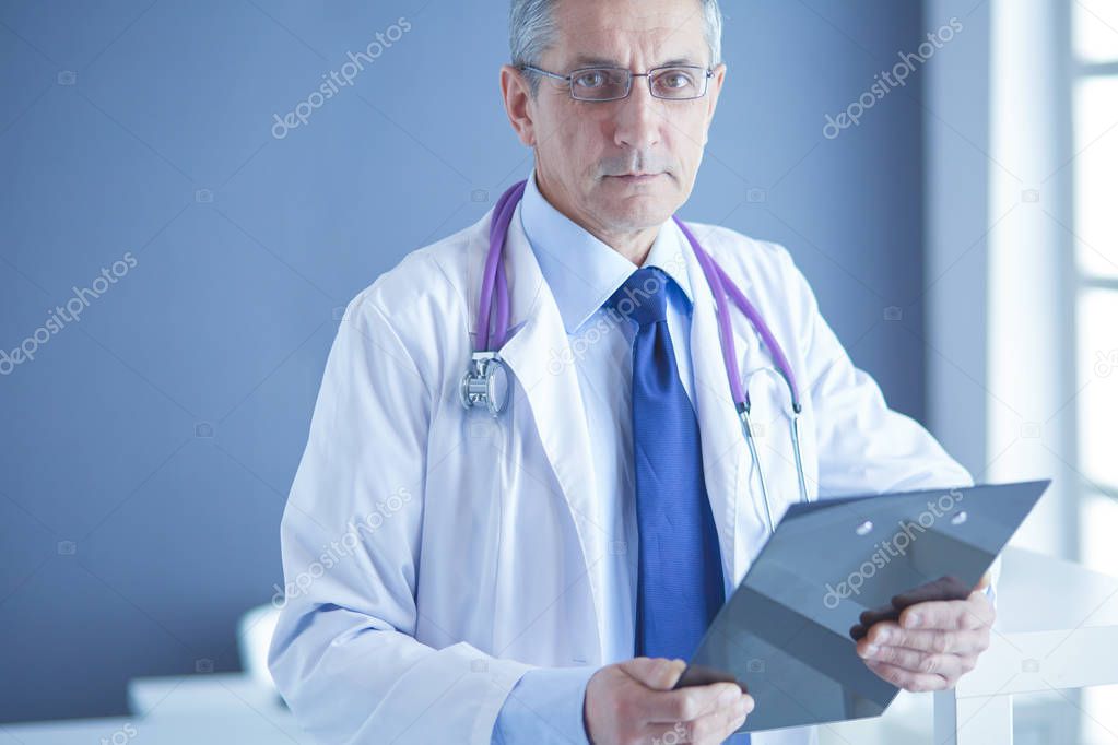 Male doctor writes notes on the clipboard in the hospital