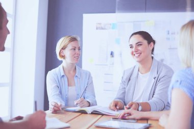 Masada kitaplarla çalışan gençler. Güzel kadınlar ve erkekler birlikte çalışıyor..