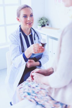 Doktor ve hasta masada otururken bir şey tartışıyorlar. İlaç ve sağlık hizmetleri kavramı