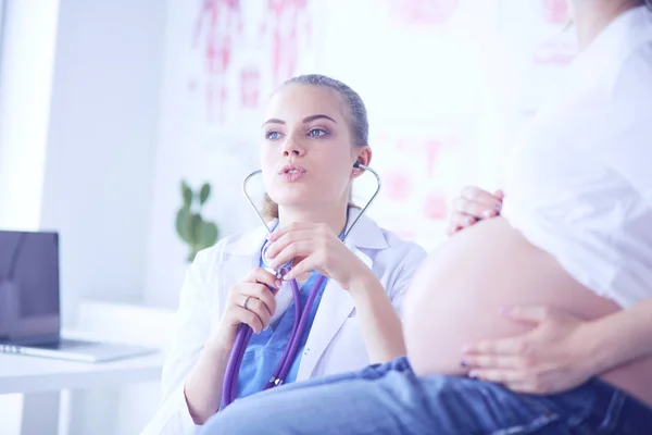 Giovane medico donna esaminando donna incinta presso la clinica. — Foto Stock