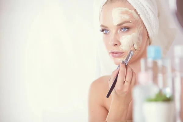 Una foto de una mujer joven aplicando polvo facial en el baño — Foto de Stock