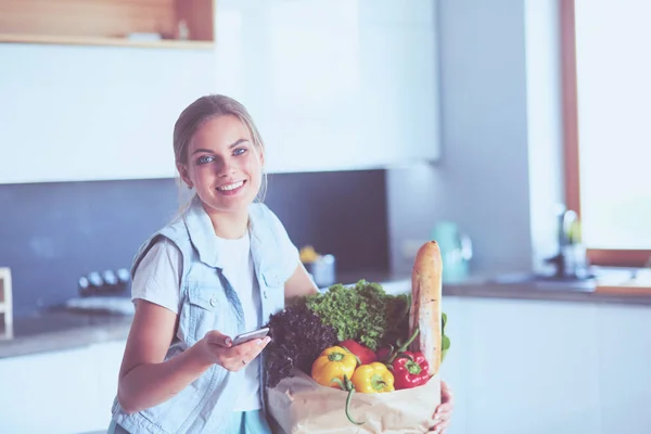 Молодая женщина держит продуктовый пакет с овощами. — стоковое фото