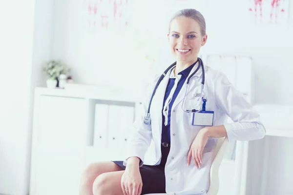 Retrato de uma jovem médica sentada à mesa no hospital — Fotografia de Stock