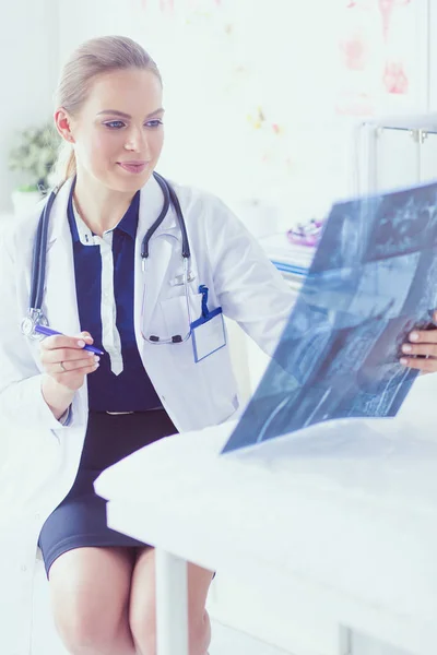 Молода приваблива жінка-лікар дивиться рентгенівське зображення — стокове фото
