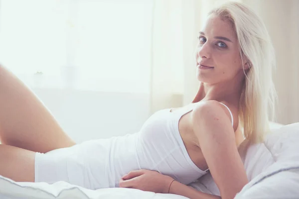 Pretty woman lying down on her bed at home — Stock Photo, Image