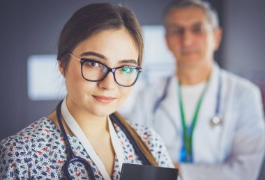 Bir doktor ekibi, kadın ve erkek, ofiste bekliyorlar.