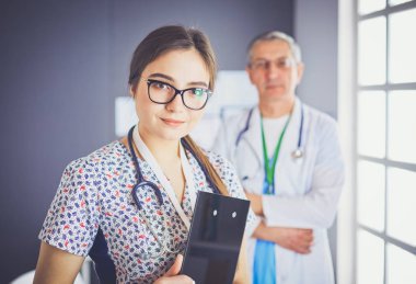 Bir doktor ekibi, kadın ve erkek, ofiste bekliyorlar.