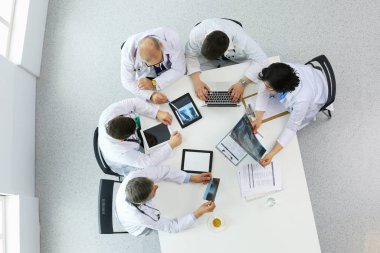 Tıbbi ekip masaya oturuyor ve tartışıyor.