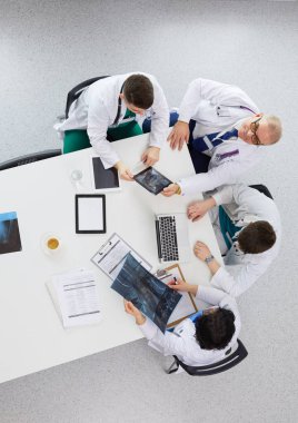 Tıbbi ekip masaya oturuyor ve tartışıyor.