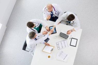 Tıbbi ekip masaya oturuyor ve tartışıyor.