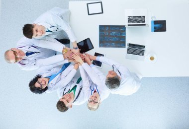 Doktorlar ve hemşireler tıbbi bir ekipte el ele tutuşuyorlar.