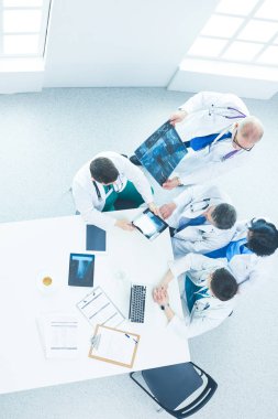 Tıbbi ekip masaya oturuyor ve tartışıyor.