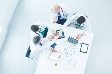 Tıbbi ekip masaya oturuyor ve tartışıyor.