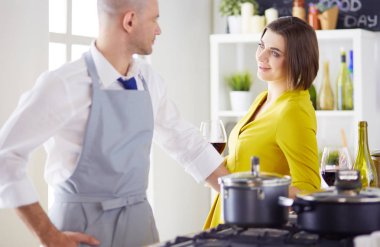 Mutfakta dijital tablet kullanan güzel genç bir kadın.