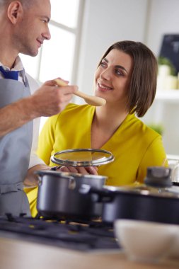 Mutfakta dijital tablet kullanan güzel genç bir kadın.