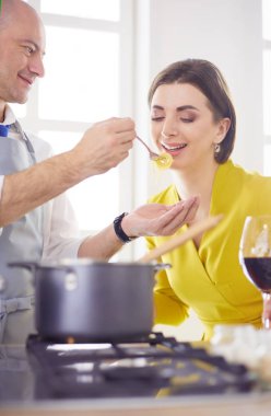 Mutfakta dijital tablet kullanan güzel genç bir kadın.