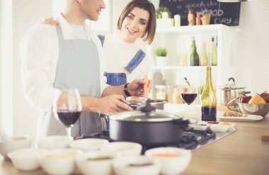 Evdeki mutfakta birlikte yemek pişiren çift.