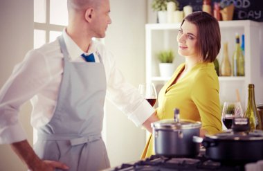 Mutfakta dijital tablet kullanan güzel genç bir kadın.