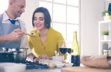 Mutfakta dijital tablet kullanan güzel genç bir kadın.