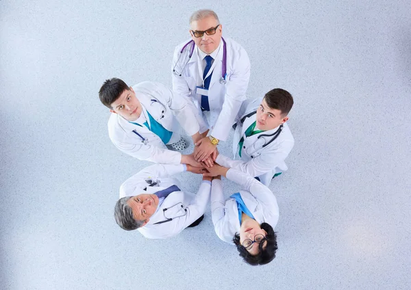 Läkare och sjuksköterskor i ett medicinskt team stapling händer, ovanifrån — Stockfoto