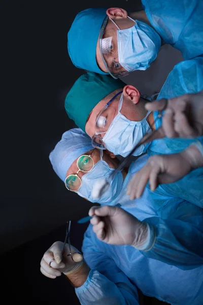 Група хірургів на роботі в операційному театрі тонована синім кольором. Операція медичної команди — стокове фото