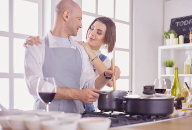 Evdeki mutfakta birlikte yemek pişiren çift.