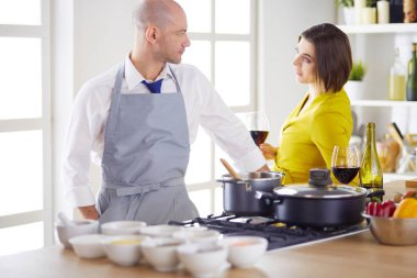 Aşık çekici bir çift yemek pişirir ve onlar romantik bir akşam yemeği pişirirken mutfakta şarap açar.