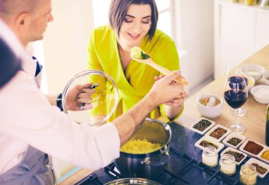 Evdeki mutfakta birlikte yemek pişiren çift.