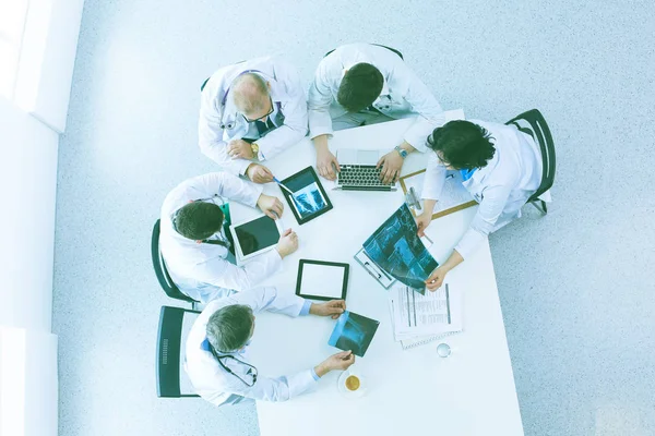 Medicinskt team sitter och diskuterar vid bordet, ovanifrån — Stockfoto