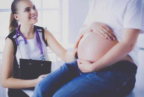 Молодая женщина-врач осматривает беременную женщину в клинике. — стоковое фото