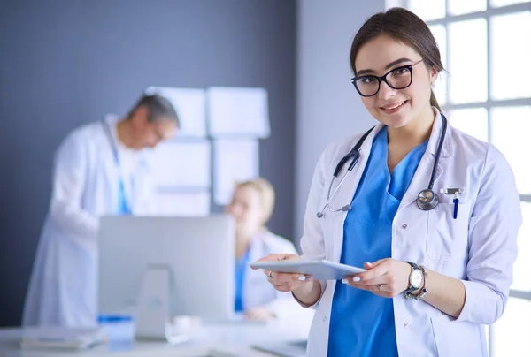 Médico femenino usando tableta en el vestíbulo del hospital —  Fotos de Stock