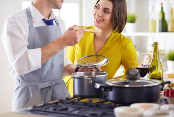 Evdeki mutfakta birlikte yemek pişiren çift.