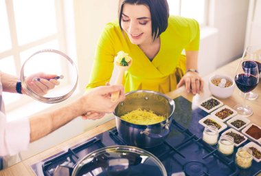 Evdeki mutfakta birlikte yemek pişiren çift.