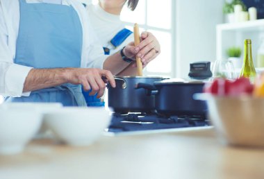 Evdeki mutfakta birlikte yemek pişiren çift.