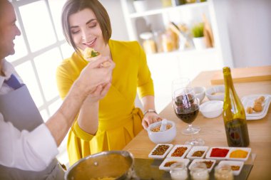 Evdeki mutfakta birlikte yemek pişiren çift.