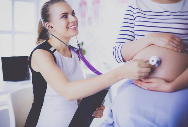 Fiatal női orvos terhes nőt vizsgál a klinikán. — Stock Fotó