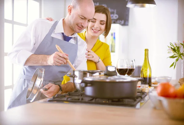 Casal atraente no amor cozinhar e abre o vinho na cozinha, enquanto eles cozinham o jantar para uma noite romântica — Fotografia de Stock