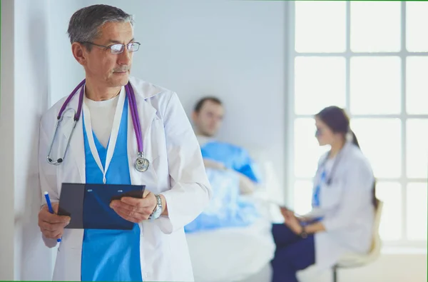 Médico segurando pasta na frente de um paciente e um médico — Fotografia de Stock