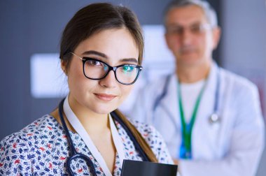 Bir doktor ekibi, kadın ve erkek, ofiste bekliyorlar.