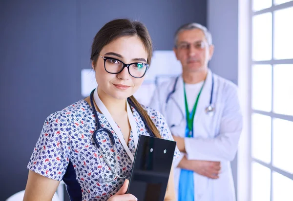 Bir doktor ekibi, kadın ve erkek, ofiste bekliyorlar.