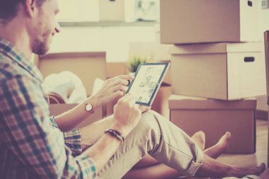 Genç bir çift yeni ev içinde hareket. Katta oturan ve açma sonra rahatlatıcı. Bir şey üstünde laptop arıyorum