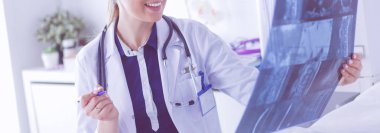 Genç ve çekici bayan doktor röntgen görüntülerine bakıyor.