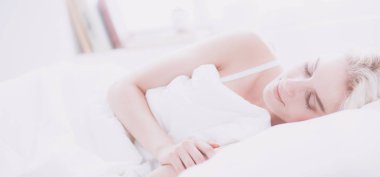 Güzel bir kadın yatağında uzanıyor.