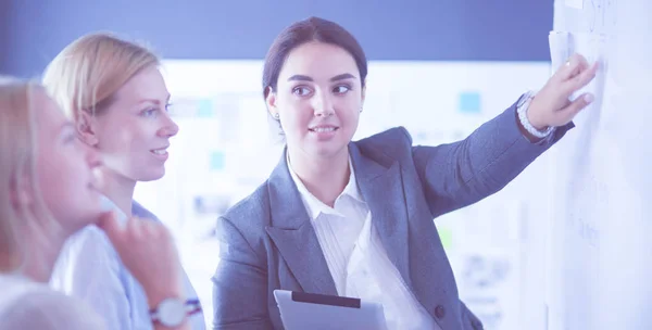 Concepto de negocio, educación y oficina - equipo de negocios con flip board en la oficina discutiendo algo. —  Fotos de Stock