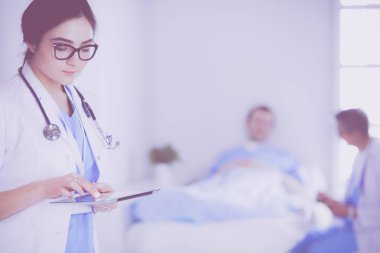 Hastane lobisinde tablet bilgisayar kullanan kadın doktor.