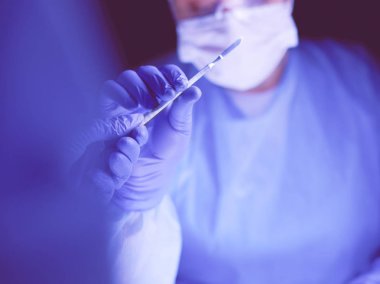 Doktor karanlık bir arka planda ameliyat yapıyor..