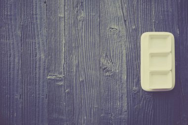 Beyaz tabakta taze kuşkonmaz servis edilir. Havan topu, ahşap masa arka planında. Üst manzara..